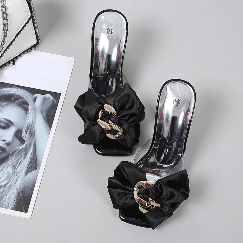 Silver high-heeled shoes with black ribbons and gold buckles