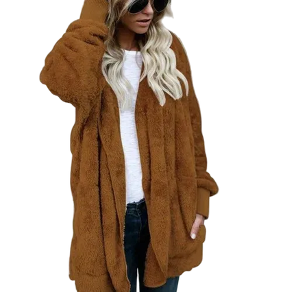 Person wearing a brown teddy coat against a gray concrete wall