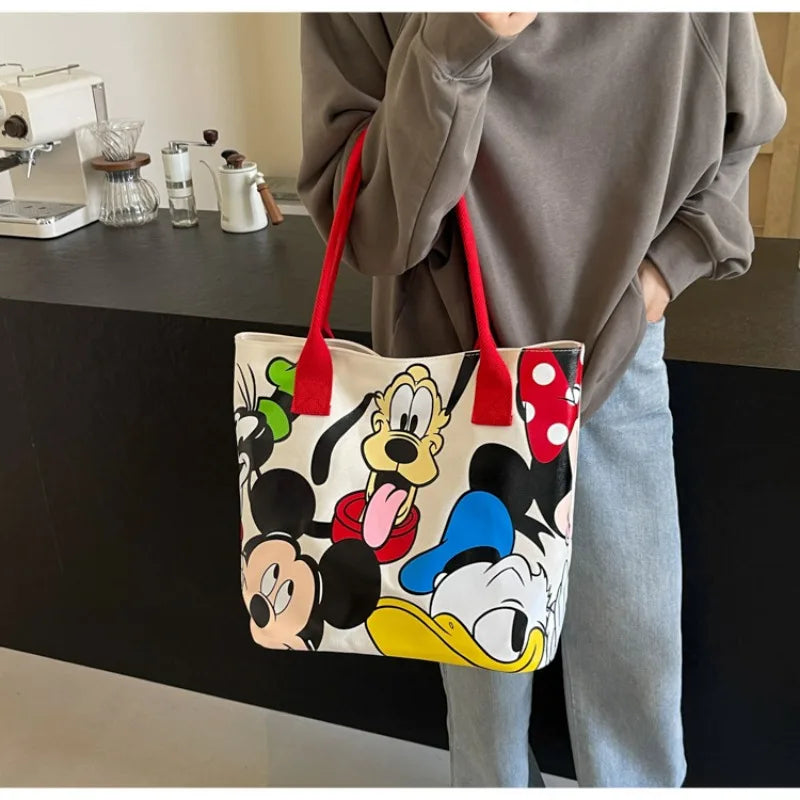 Person holding a tote bag with cartoon character designs in an indoor setting.
